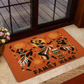 Orange African dance doormat styled inside a glass doorway with a neutral floor and floral arrangement