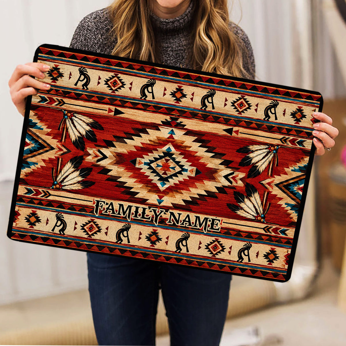 American Native doormat held indoors, displaying bold geometric artwork, feather details, and a family-centered design