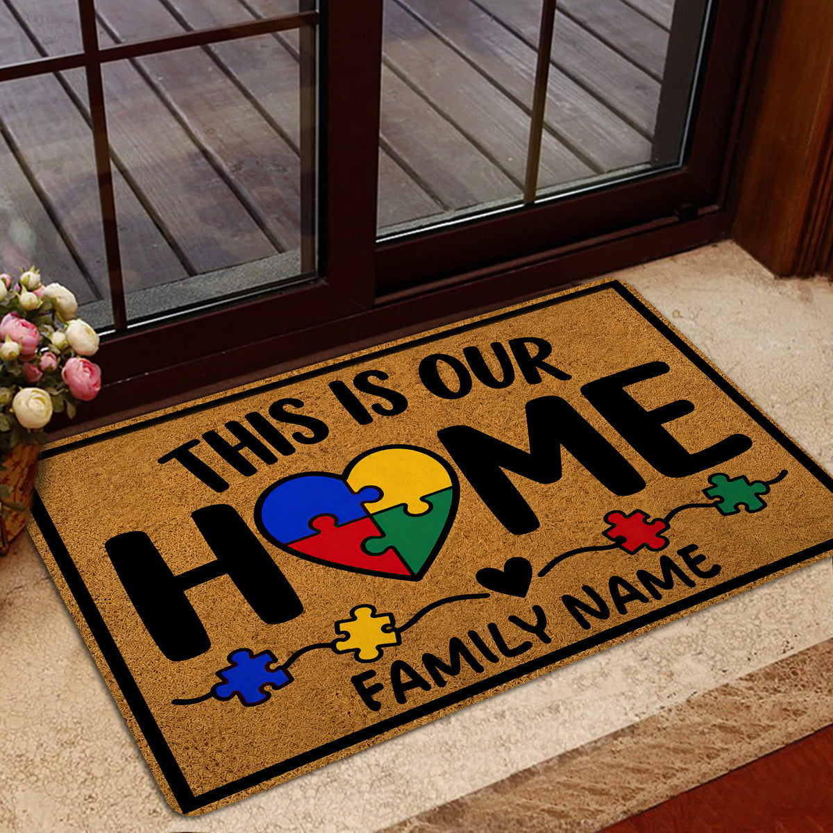Autism-themed family welcome doormat styled near a glass door with colorful puzzle-piece artwork