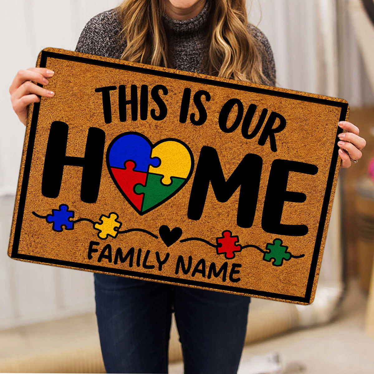 Autism doormat with colorful puzzle pieces and heart design held indoors for a product presentation