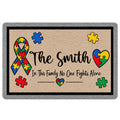 Autism awareness doormat with a colorful puzzle-piece ribbon, hearts, and a supportive family message
