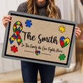 Person holding a colorful autism awareness doormat with puzzle pieces and heart artwork