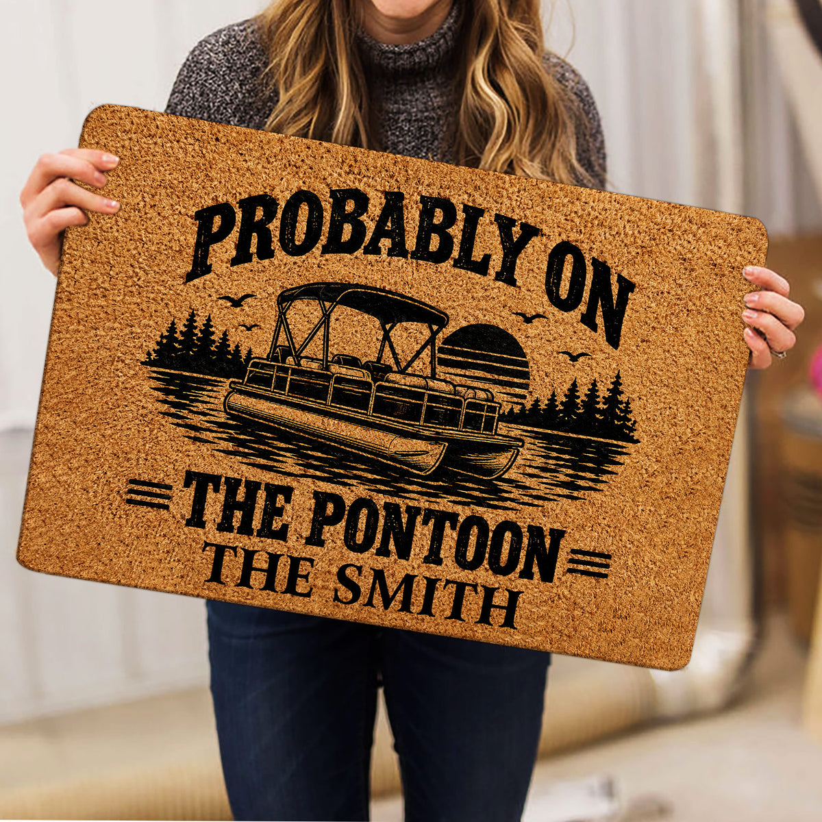 Pontoon boat doormat held indoors, showing the lake scene, sunset and vintage lettering