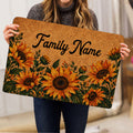 Sunflower doormat held indoors, showing golden floral artwork and dark green leaves