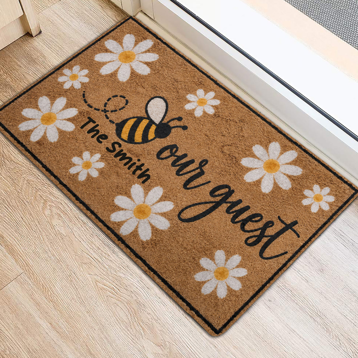 Floral bee door mat positioned beside a bright doorway on light wood flooring