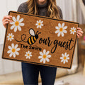 Person holding a bee and daisy doormat featuring a warm floral welcome design