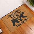 Bear welcome doormat displayed in an indoor entryway on a warm wood floor beside a white door