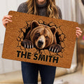 Person holding a bear doormat featuring realistic wildlife artwork, textured brown tones, and bold lettering