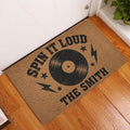 Rock and roll vinyl record doormat displayed at an indoor entryway beside a white door