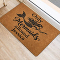 Mermaid door mat positioned near a doorway, featuring a black mermaid illustration and lettering