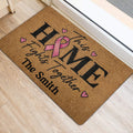 Pink ribbon breast cancer doormat styled beside an interior doorway on light flooring