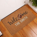 Football welcome doormat displayed at a home entrance beside a white door and wood flooring