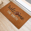 Football-themed door mat placed at an entryway with a warm brown design and football graphic