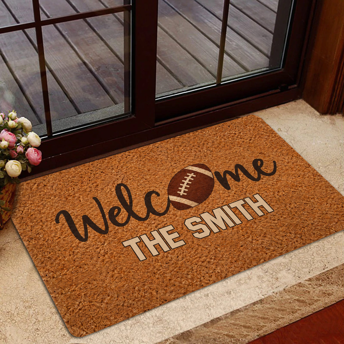 Football welcome mat styled inside a home entrance near glass doors and a wood threshold