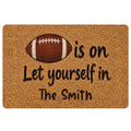 Football-themed doormat with a classic brown football graphic and welcoming black lettering