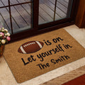 Football-themed entryway mat positioned near a glass door in a home entrance