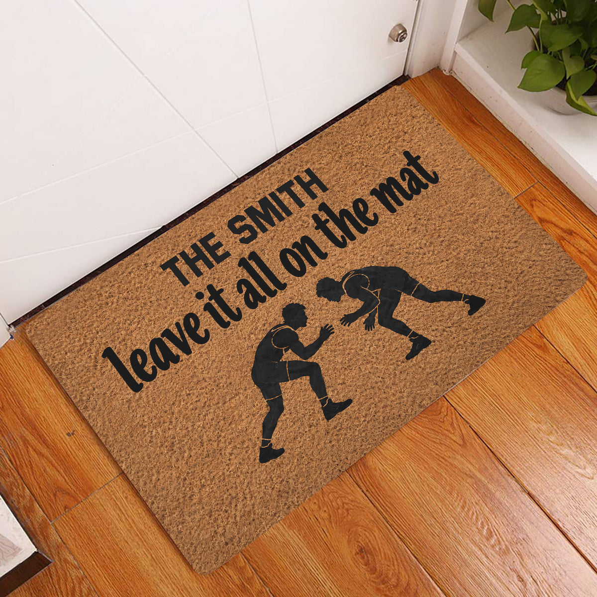 Wrestling doormat displayed at an indoor doorway on warm hardwood flooring