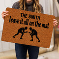 Person holding a wrestling doormat with two grapplers and bold black artwork