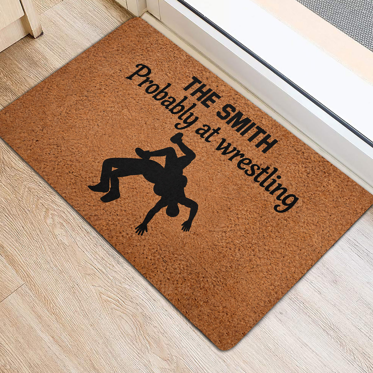 Wrestling silhouette doormat displayed near a doorway on light wood flooring