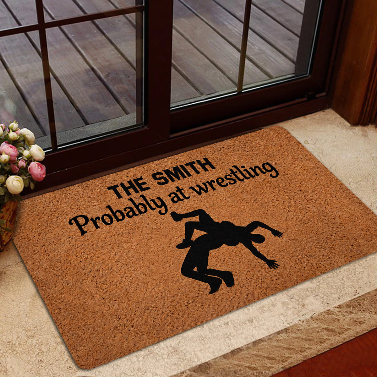 Wrestling-themed door mat shown in a home entrance beside glass doors and an indoor rug