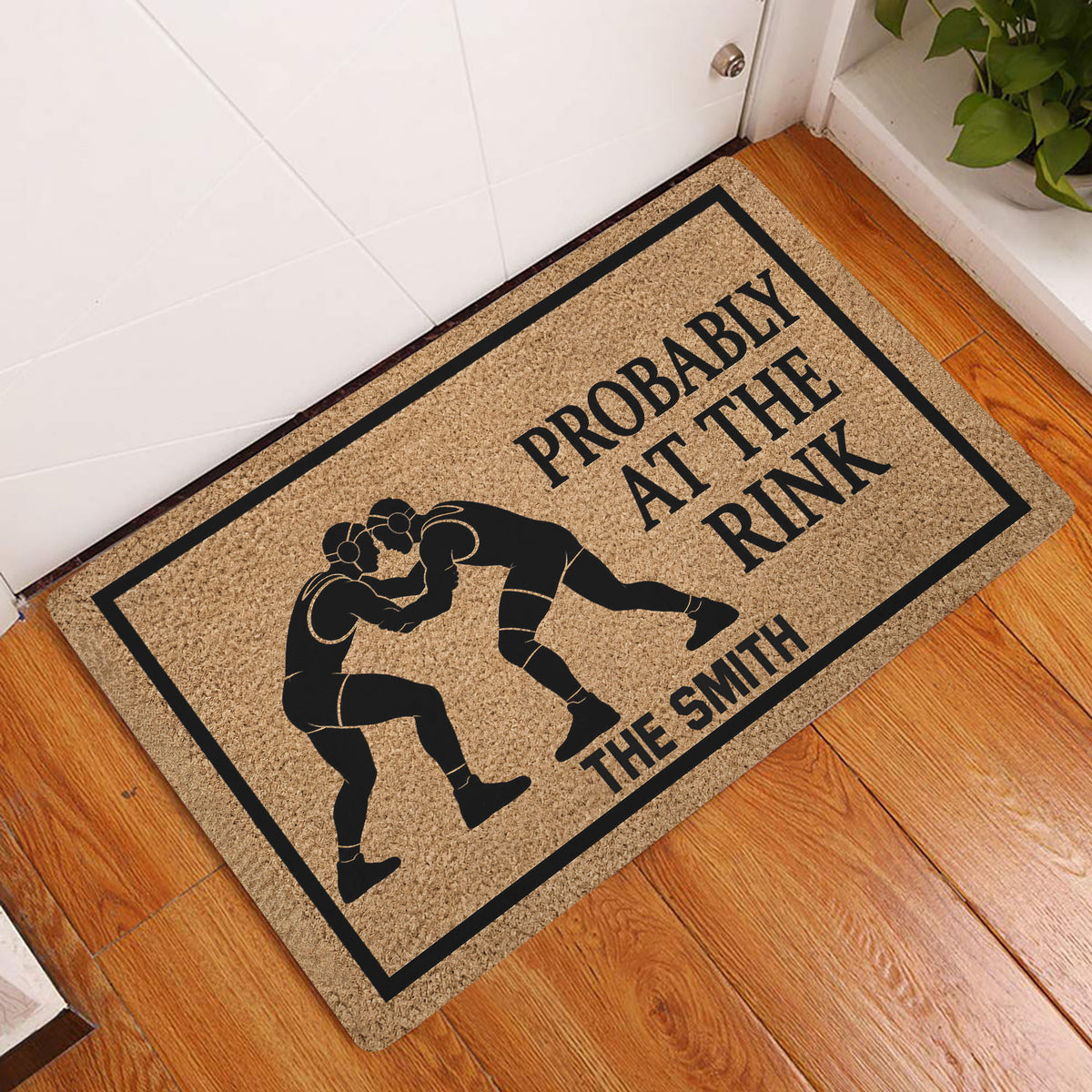 Wrestling doormat styled at a front door on hardwood flooring with grappler artwork and bold lettering