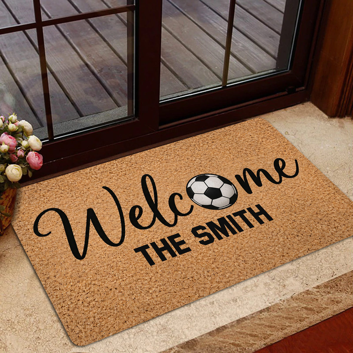 Soccer welcome rug styled in a home entrance beside a glass door