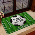 Soccer-themed doormat displayed near a glass entrance with a green field design