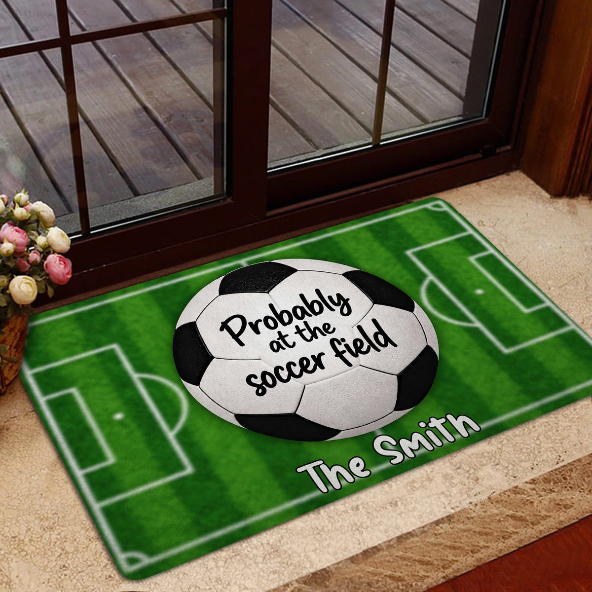 Soccer-themed doormat displayed near a glass entrance with a green field design