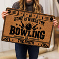Bowling doormat held indoors, displaying bold black bowling artwork on a tan background