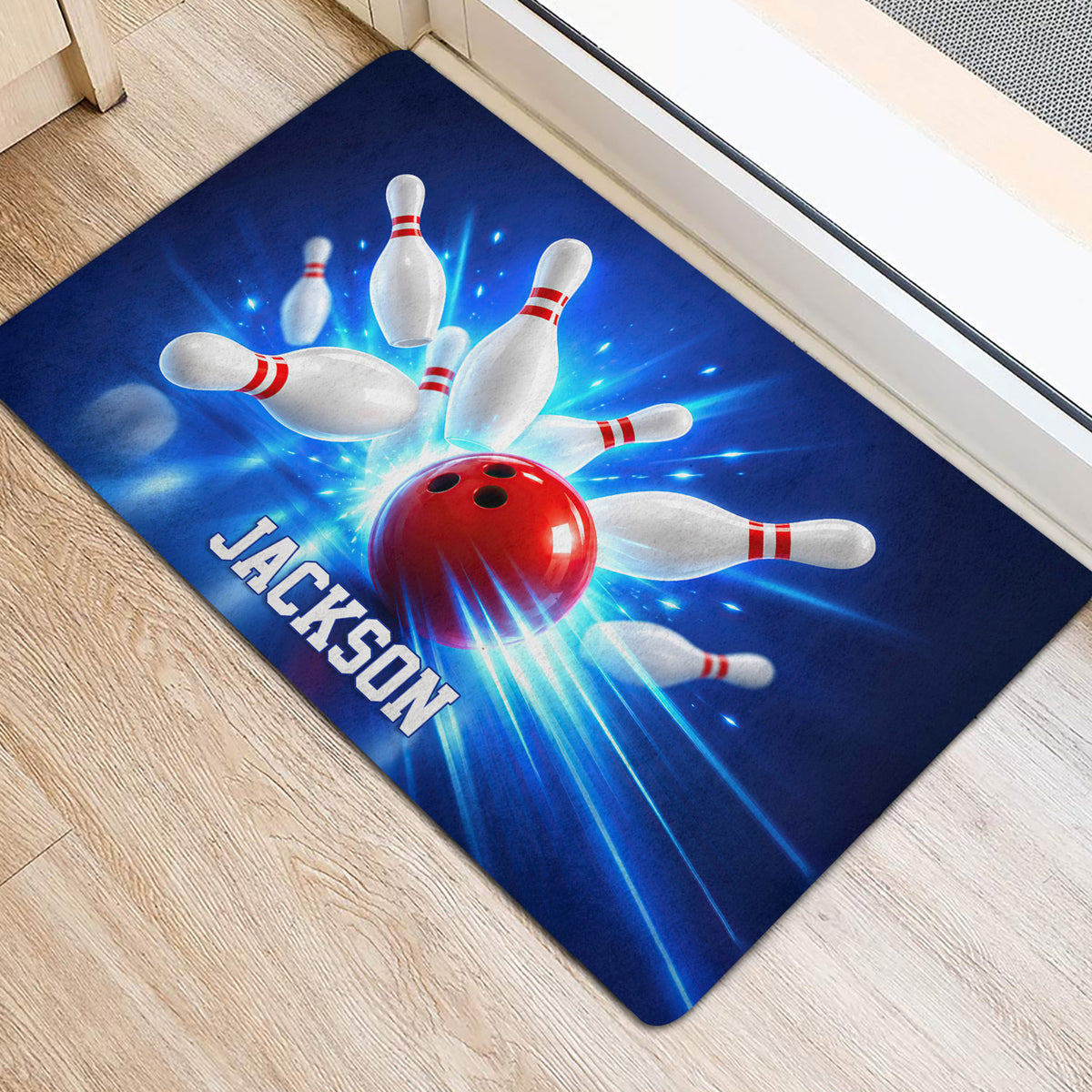 Bowling ball and scattered pins doormat positioned beside an indoor door on light wood flooring