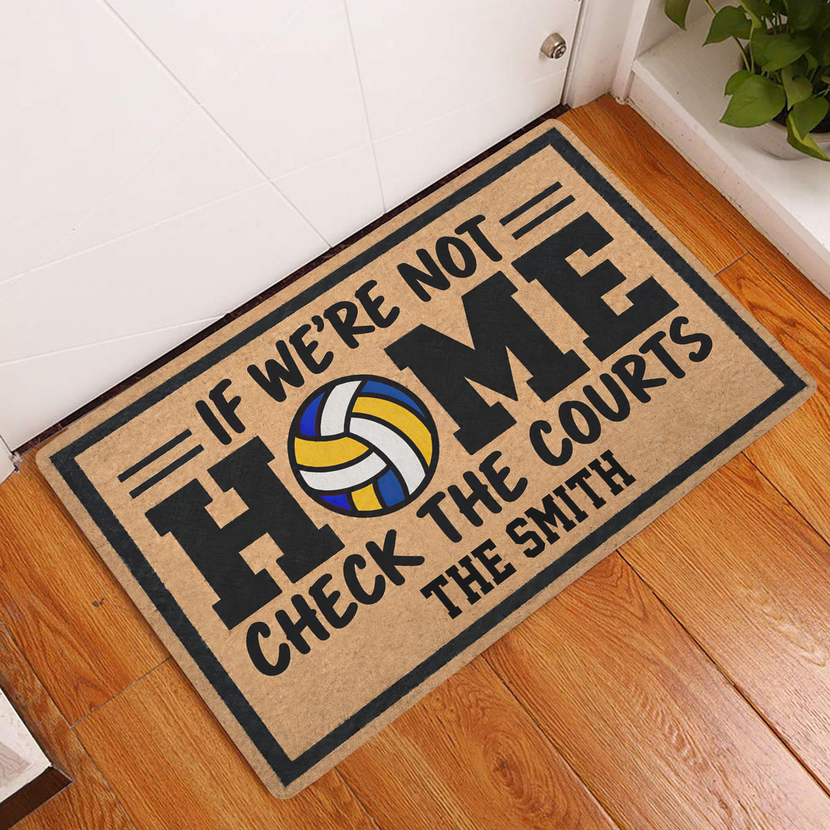 Volleyball doormat displayed at an indoor entryway beside a white door and wood floor