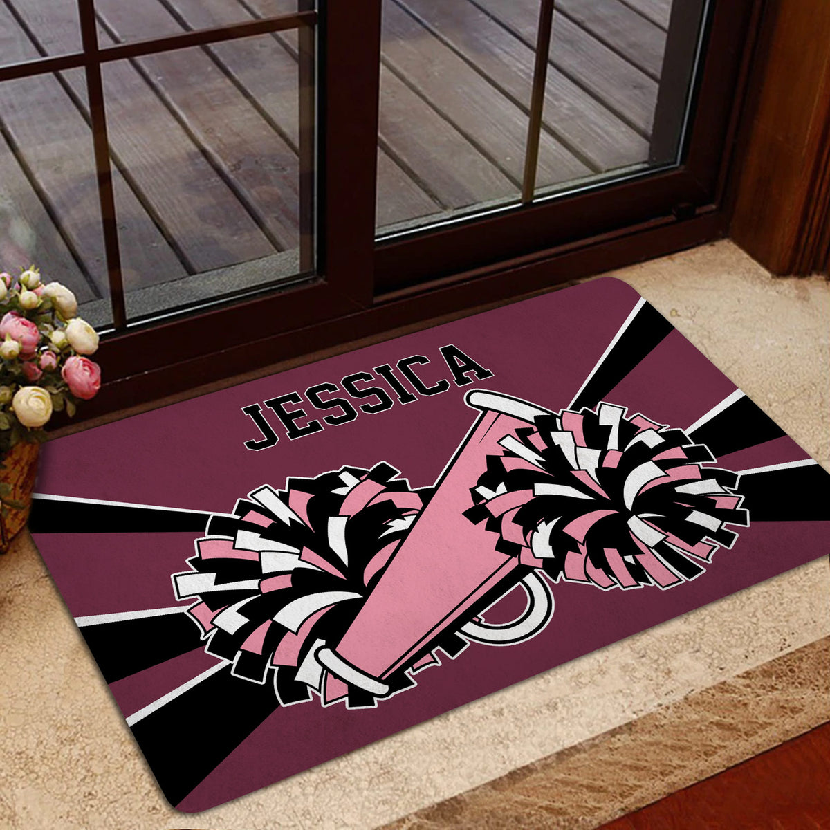 Pink and burgundy cheerleading doormat styled inside a home entryway with pom-pom and megaphone artwork