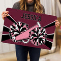 Person holding a cheerleading doormat with colorful pom-poms and megaphone artwork in a home setting