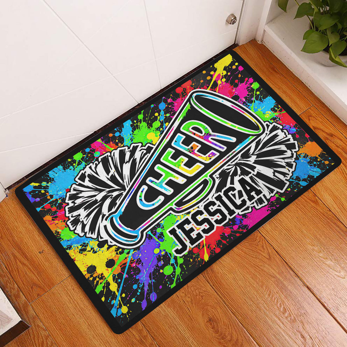 Colorful cheerleading doormat displayed in an entryway on a wood floor beside a white door