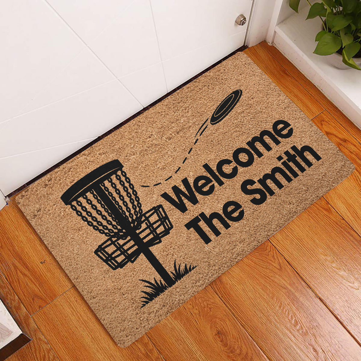 Disc golf welcome doormat displayed at an indoor entryway with a basket and flying disc design