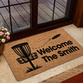 Disc golf welcome mat displayed inside a glass doorway with a basket and flying disc graphic