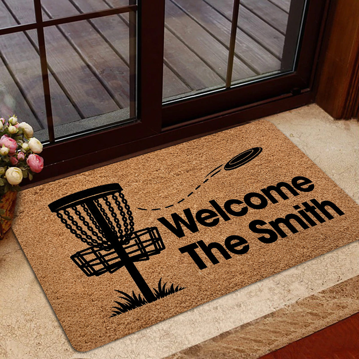 Disc golf welcome mat displayed inside a glass doorway with a basket and flying disc graphic