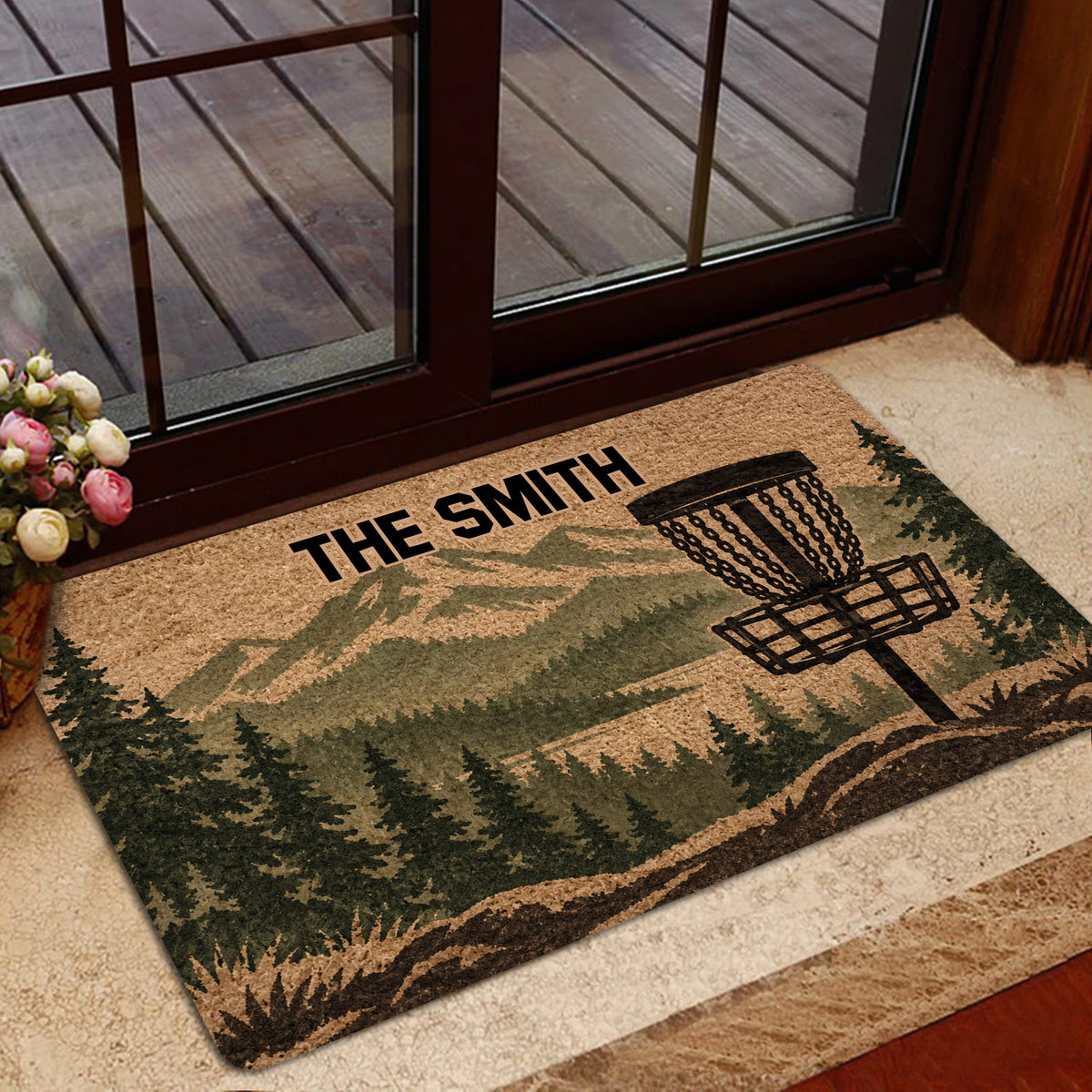 Disc golf entryway mat displayed near glass doors with a forest landscape design