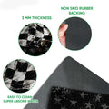 Close-up view of a dirt track racing doormat showing the checkered flag print and dark rubber backing