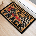 Racing tire and checkered flag doormat styled beside a doorway on a light wood floor