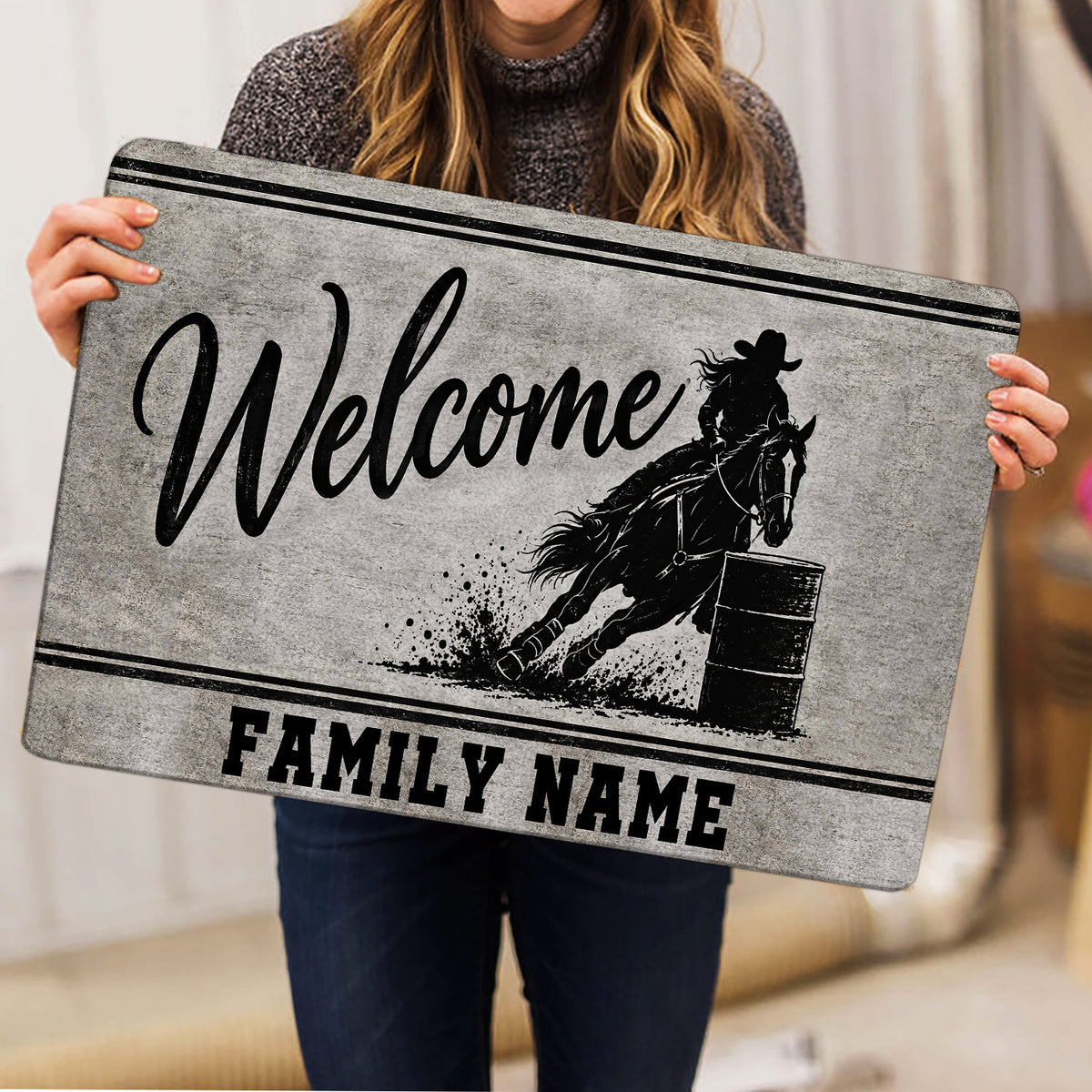 Barrel racing welcome doormat held indoors showing the horse and rider artwork in black and gray