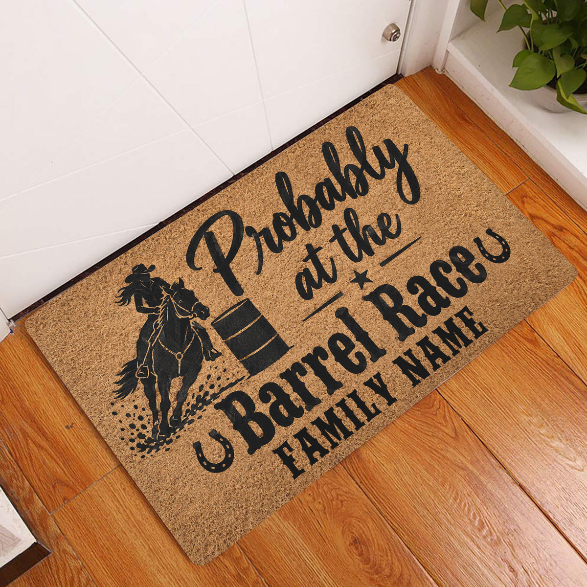 Barrel racing entryway mat displayed on a wood floor beside a white door