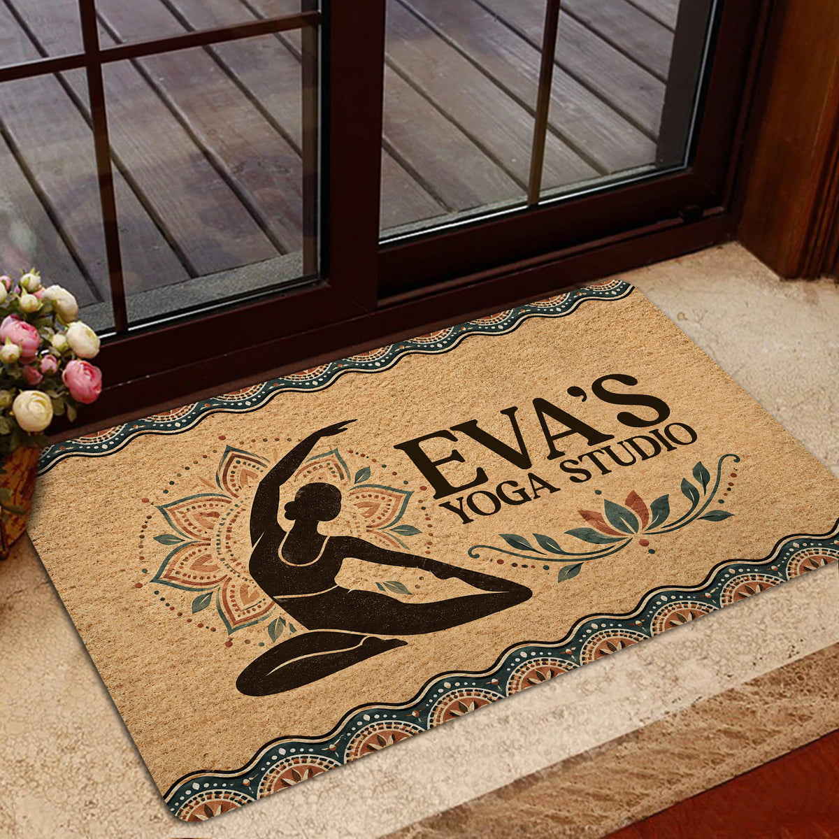 Yoga doormat displayed near a glass doorway, featuring earthy mandala artwork and a seated yoga silhouette