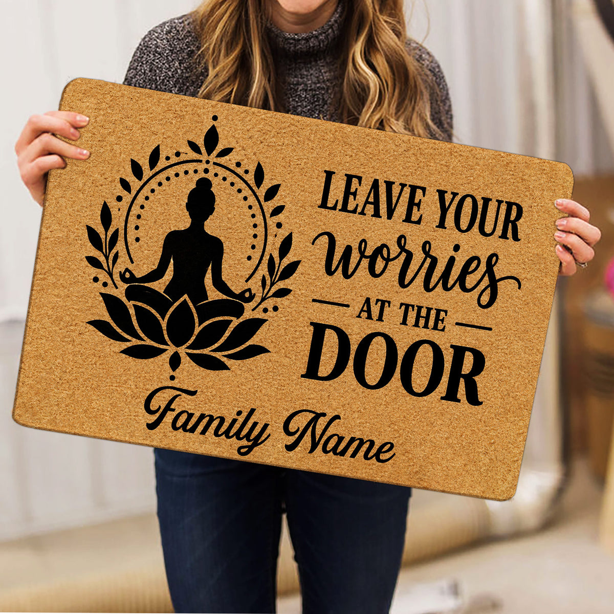 Person holding a yoga doormat displaying a meditating figure, lotus design, inspirational message, and family-focused layout