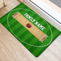 Green cricket pitch door mat positioned near an entryway with a cricket ball design