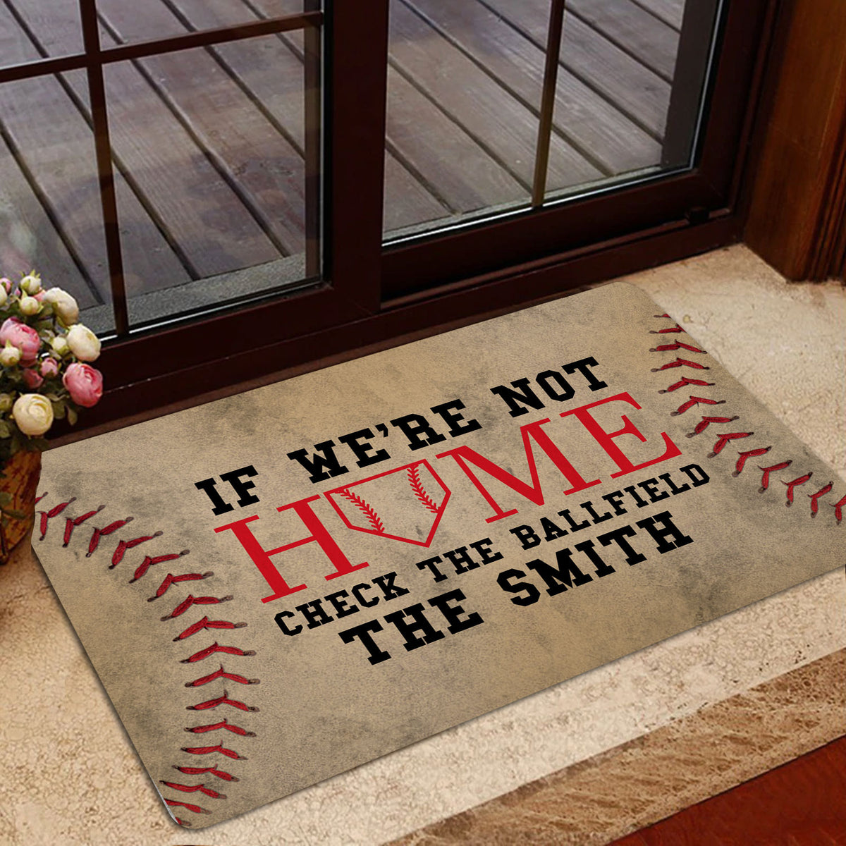 Baseball doormat styled at a glass entry door with red stitching details and ballfield artwork