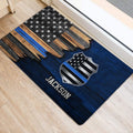 Blue line police badge doormat placed near an interior doorway on a light wood floor