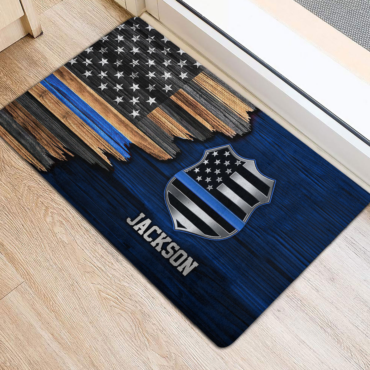 Blue line police badge doormat placed near an interior doorway on a light wood floor