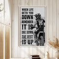 Motocross wall art displayed in a bright wood-paneled room above a small stack of books