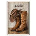 Framed cowboy wall art featuring a western hat and leather boots against a rustic wood backdrop